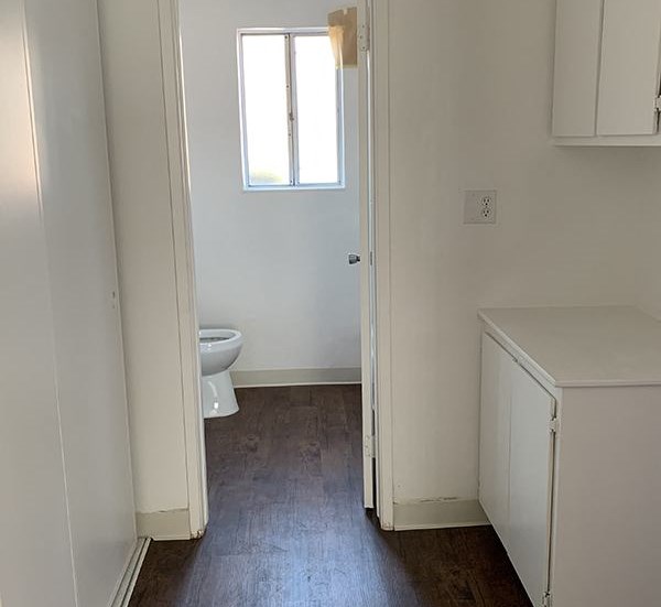 Hallway to bathroom with wood flooring